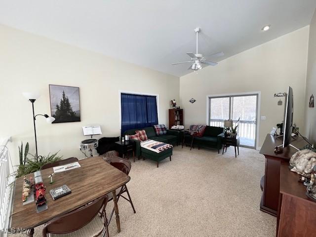 living room with light carpet, high vaulted ceiling, and ceiling fan