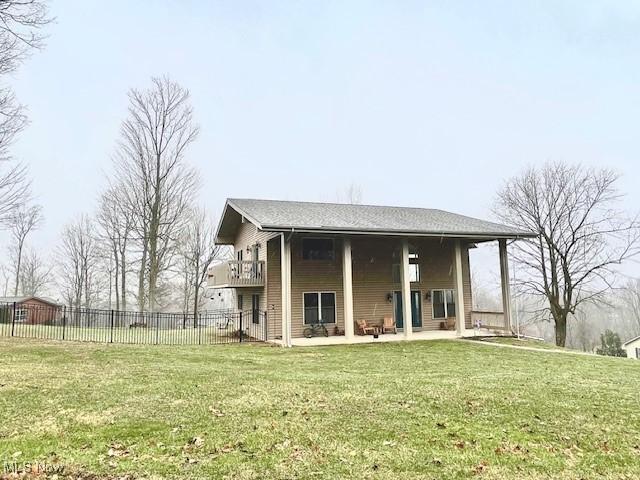 back of property featuring a patio and a lawn