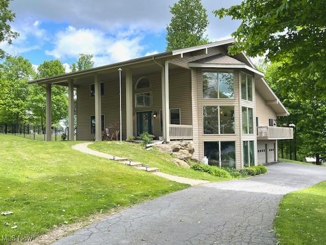 7716 N Ridge Pl, Lisbon, OH 44432 - view of front of property featuring asphalt driveway, a garage, and a front yard