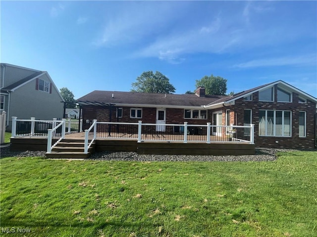 back of property featuring a deck, a pergola, and a lawn