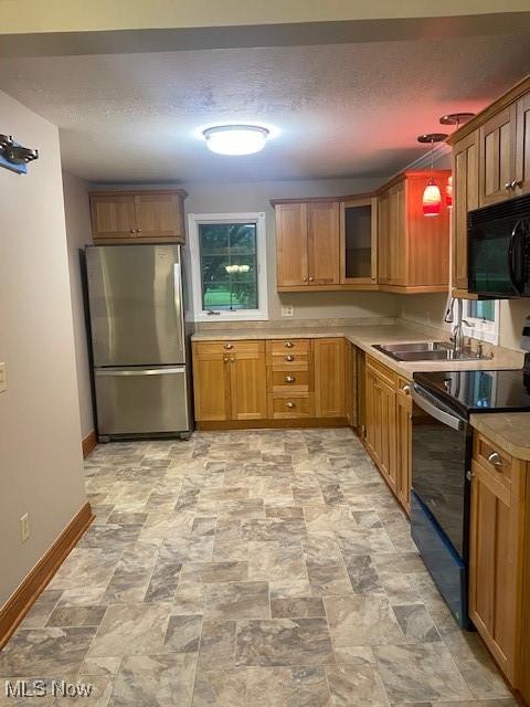 kitchen featuring decorative light fixtures, sink, and black appliances