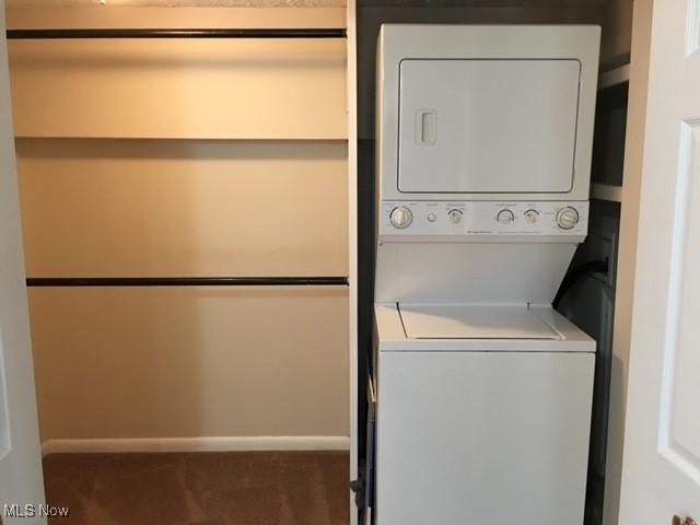 clothes washing area featuring stacked washer and dryer