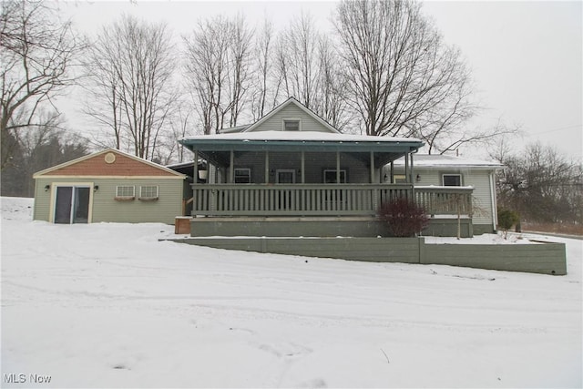 view of front of house with an AC wall unit and a porch