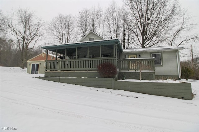 snow covered rear of property with a porch