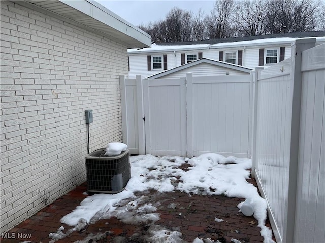 snow covered structure with central air condition unit