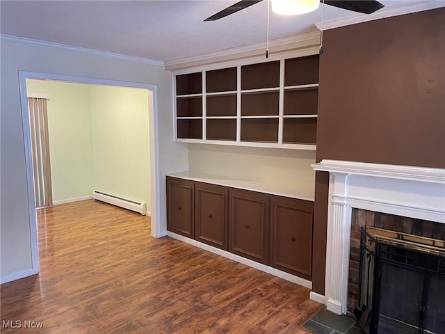 unfurnished living room featuring baseboard heating, a fireplace, ornamental molding, and hardwood / wood-style flooring