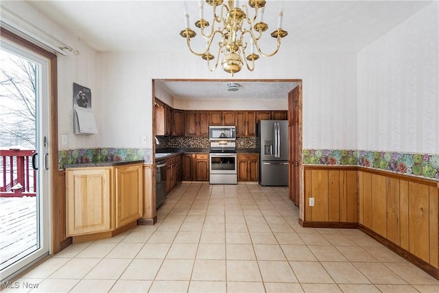 kitchen featuring decorative light fixtures, appliances with stainless steel finishes, tasteful backsplash, and a chandelier