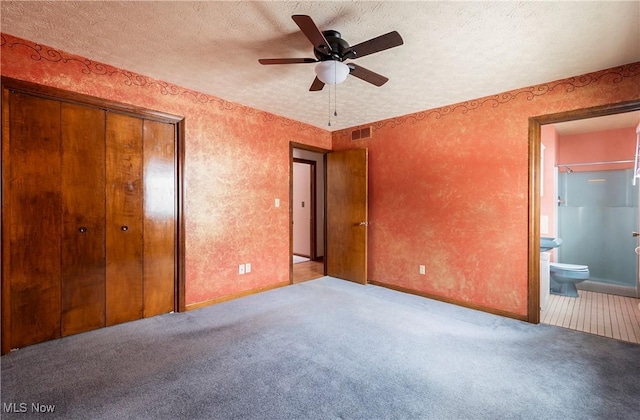 unfurnished bedroom featuring ceiling fan, a textured ceiling, ensuite bathroom, and light carpet