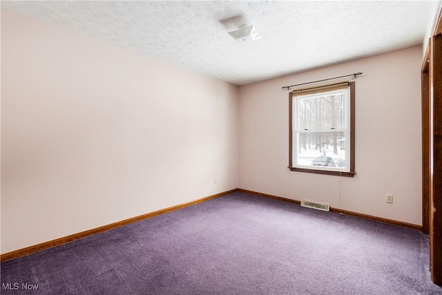 carpeted spare room featuring a textured ceiling