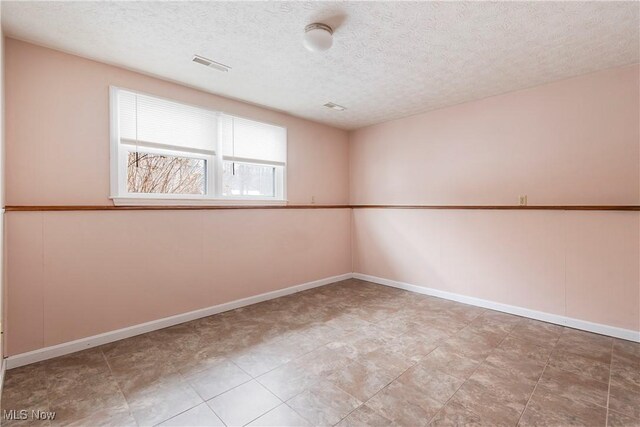 spare room featuring a textured ceiling