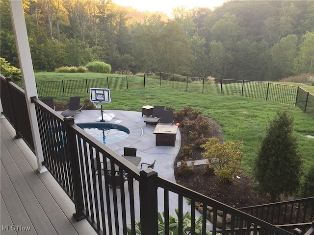 deck at dusk featuring a patio area, outdoor lounge area, and a yard