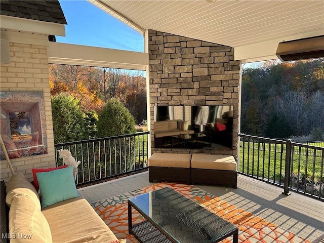 balcony with an outdoor living space with a fireplace