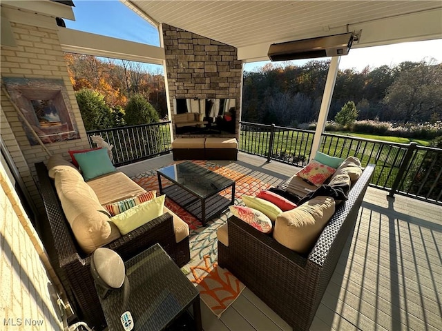 deck with an outdoor living space with a fireplace