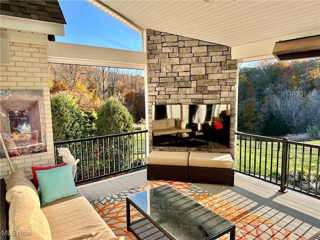 balcony with an outdoor living space with a fireplace