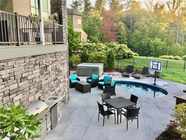 view of pool featuring a patio area, a hot tub, and an outdoor kitchen