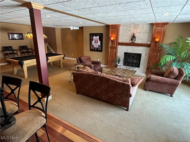 living room with carpet, pool table, and a stone fireplace