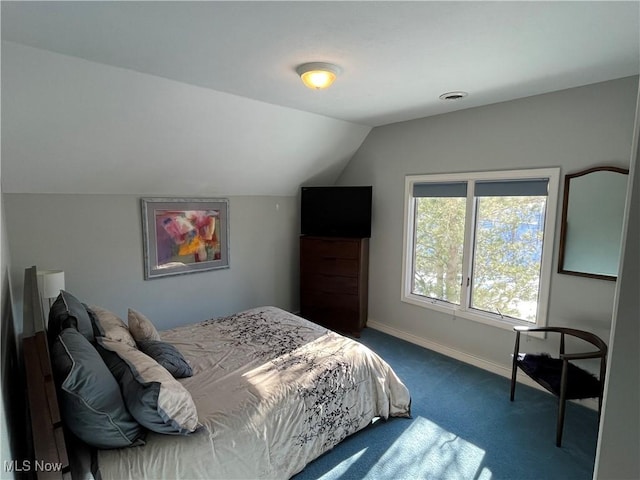 bedroom with lofted ceiling and dark carpet