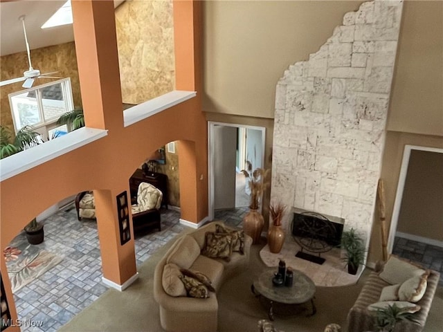 living room with ceiling fan and a fireplace