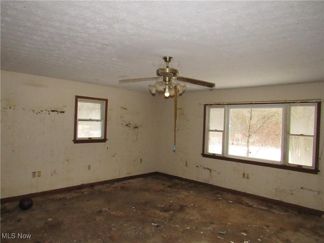 empty room with a textured ceiling and ceiling fan