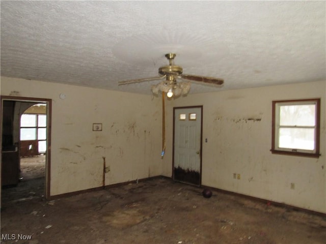 empty room featuring a textured ceiling and ceiling fan