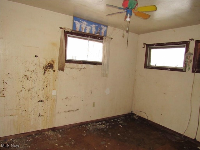 spare room featuring ceiling fan and a wealth of natural light