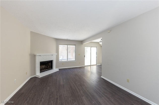 unfurnished living room with dark hardwood / wood-style flooring and a fireplace