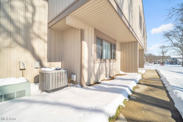 snow covered property featuring central AC