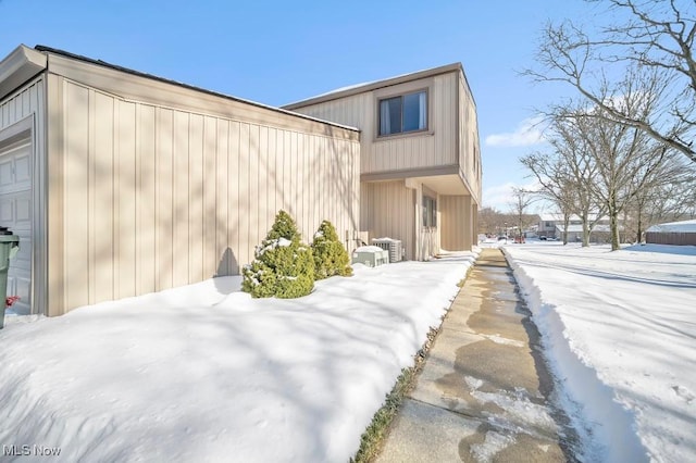 view of snow covered exterior featuring a garage