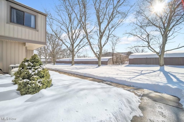 yard layered in snow featuring central air condition unit