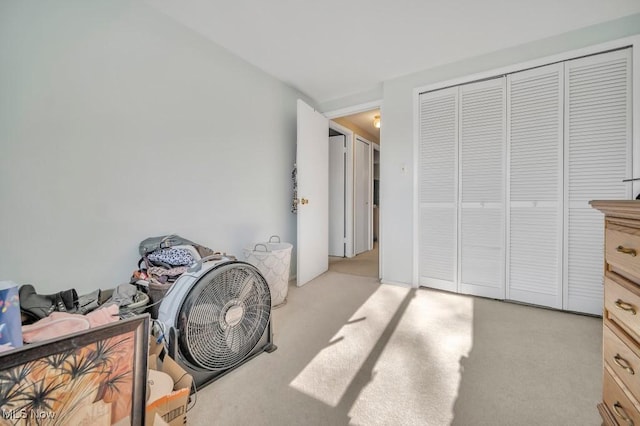 bedroom with light colored carpet and a closet