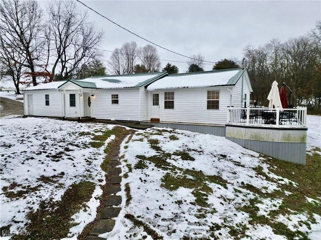 snow covered house featuring a wooden deck