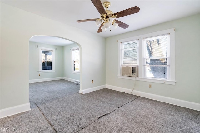 carpeted spare room with ceiling fan, a healthy amount of sunlight, and cooling unit