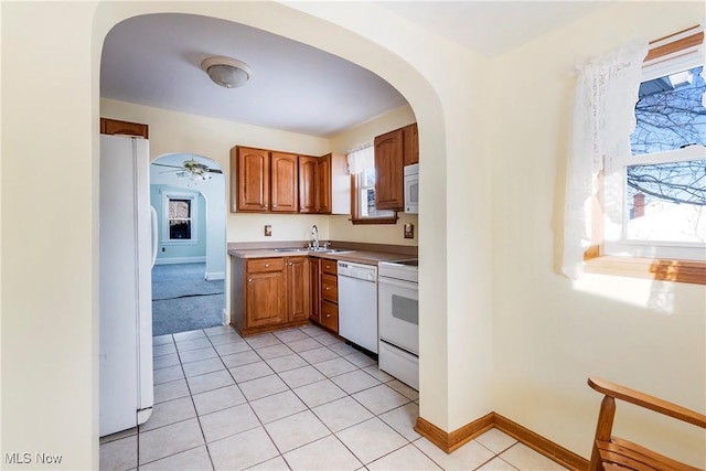 kitchen featuring ceiling fan, sink, white appliances, and light tile patterned floors