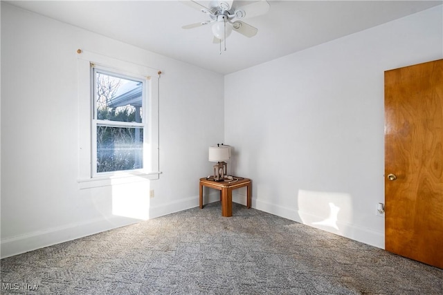 carpeted spare room with ceiling fan