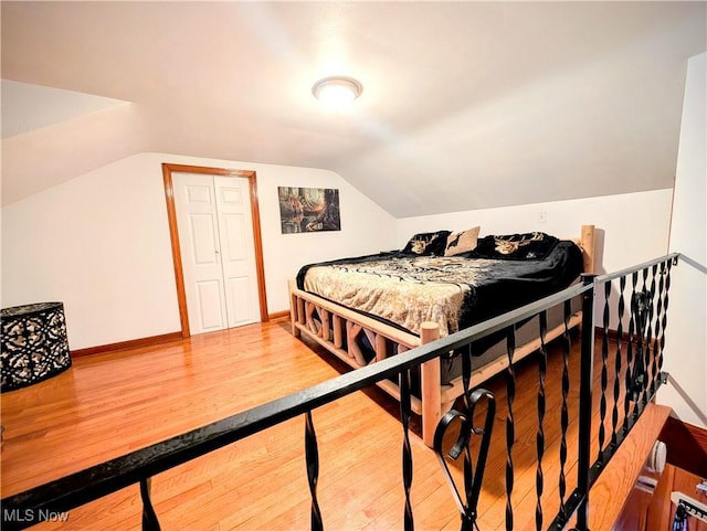 bedroom featuring hardwood / wood-style floors and vaulted ceiling