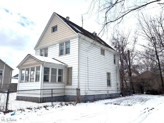 view of snow covered exterior featuring a sunroom