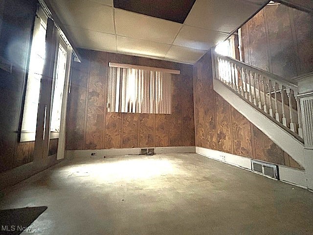 spare room with concrete floors and wooden walls