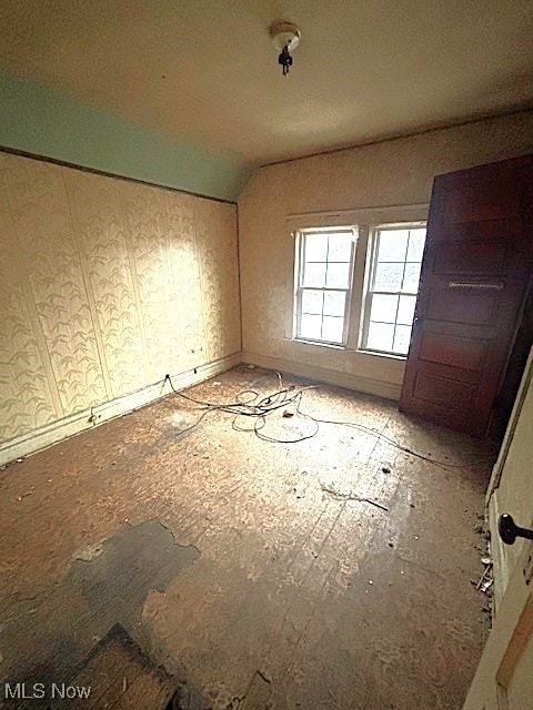 empty room featuring vaulted ceiling