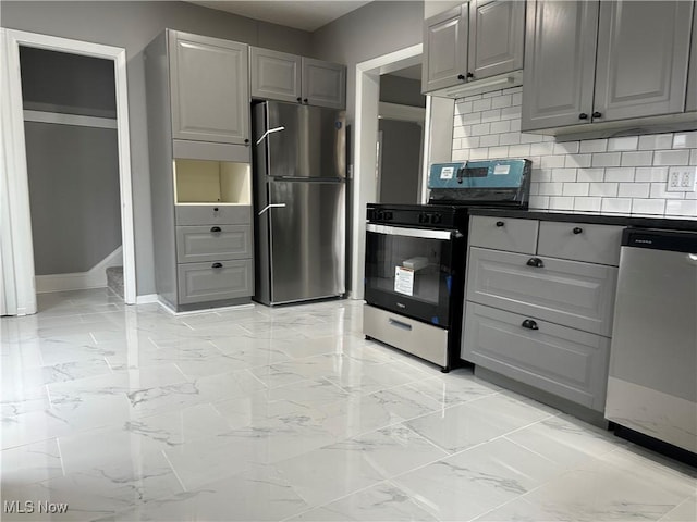 kitchen with stainless steel appliances, gray cabinetry, and tasteful backsplash