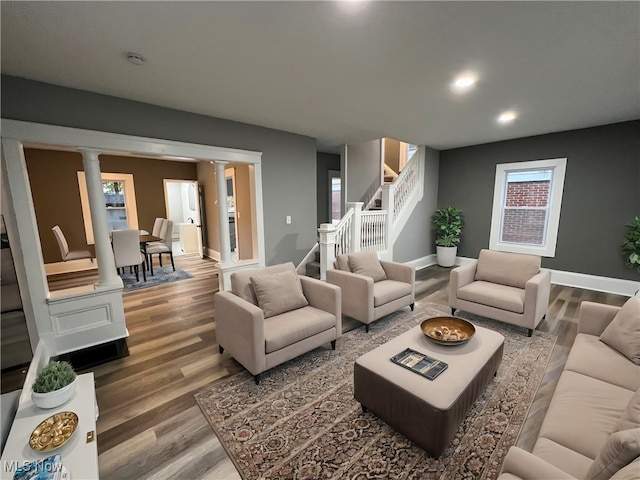 living room with wood-type flooring and decorative columns