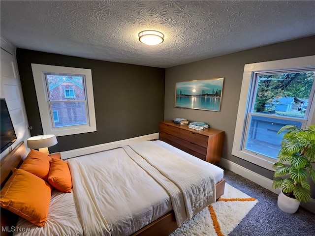 bedroom featuring a textured ceiling and carpet flooring