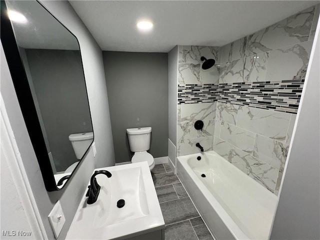 full bathroom with toilet, tiled shower / bath, and vanity