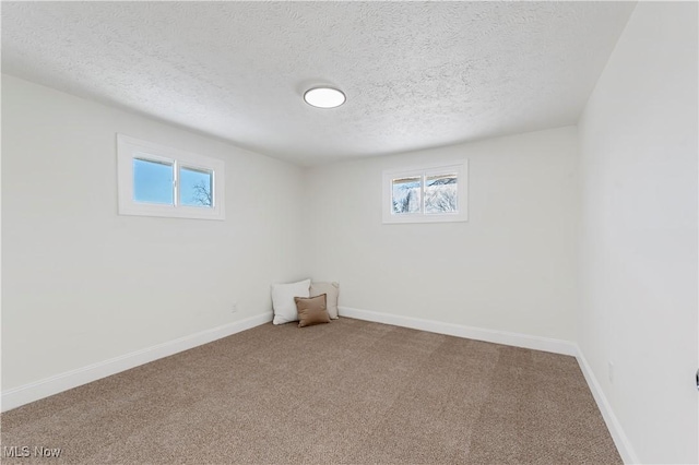 empty room with a textured ceiling and carpet