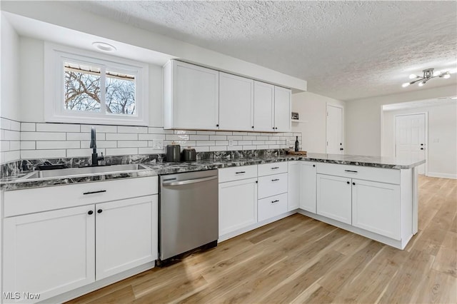 kitchen with white cabinetry, decorative backsplash, dishwasher, and sink