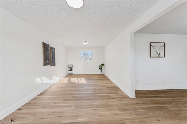 washroom with a textured ceiling and light hardwood / wood-style flooring