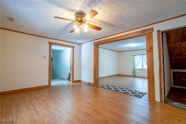 spare room with light wood-type flooring, ceiling fan, and ornamental molding