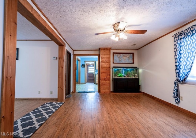 unfurnished living room featuring hardwood / wood-style flooring, a textured ceiling, crown molding, and ceiling fan