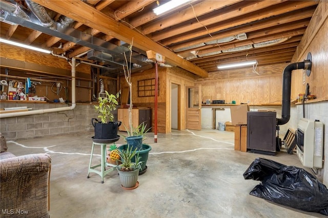 basement with a wood stove and heating unit