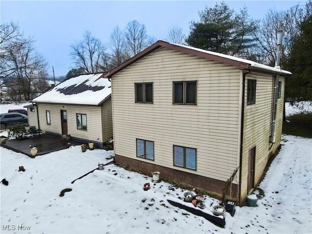 view of snow covered rear of property