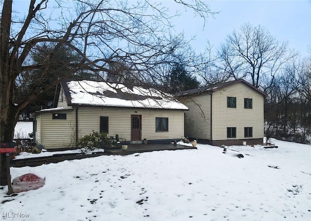 view of snow covered back of property